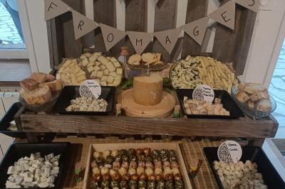 Un groupe de personnes assises et debout dans une salle avec des poutres apparentes, participant à une présentation.