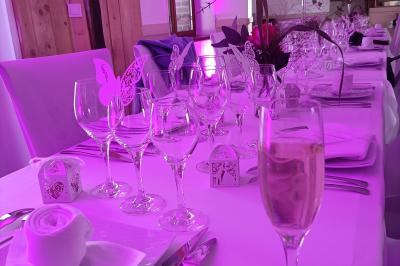 Un groupe de personnes assises et debout dans une salle avec des poutres apparentes, participant à une présentation.