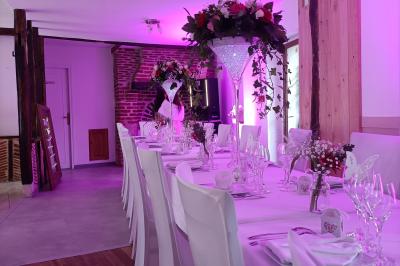 Un groupe de personnes assises et debout dans une salle avec des poutres apparentes, participant à une présentation.