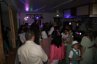 Un groupe de personnes assises et debout dans une salle avec des poutres apparentes, participant à une présentation.