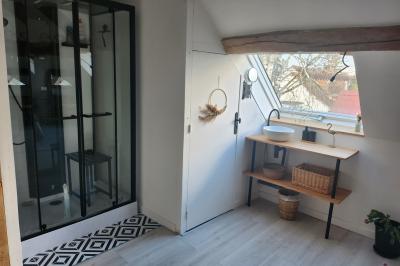 Un groupe de personnes assises et debout dans une salle avec des poutres apparentes, participant à une présentation.