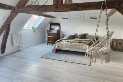 Un groupe de personnes assises et debout dans une salle avec des poutres apparentes, participant à une présentation.