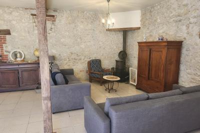 Un groupe de personnes assises et debout dans une salle avec des poutres apparentes, participant à une présentation.