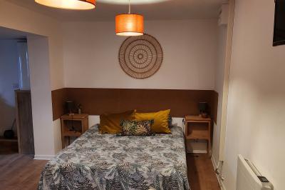 Un groupe de personnes assises et debout dans une salle avec des poutres apparentes, participant à une présentation.