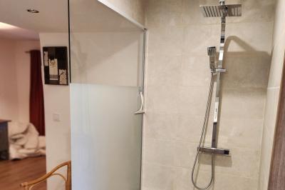 Un groupe de personnes assises et debout dans une salle avec des poutres apparentes, participant à une présentation.