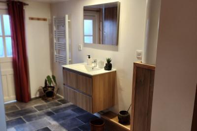 Un groupe de personnes assises et debout dans une salle avec des poutres apparentes, participant à une présentation.