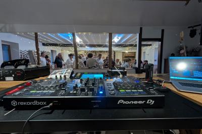 Un groupe de personnes assises et debout dans une salle avec des poutres apparentes, participant à une présentation.