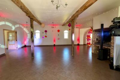 Entrée d'un bâtiment en briques avec porte ouverte, escaliers, pots de fleurs et haut-parleurs disposés de chaque côté.