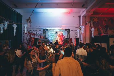 Comptoir en bois d'un bar à thème tropical avec tabourets pliants, éclairage en paille et décoration végétale.