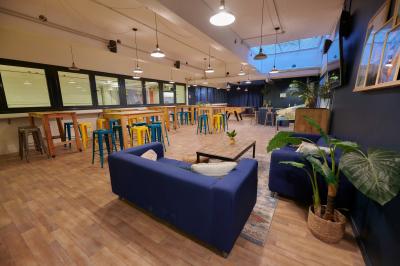 Des personnes participent à un jeu d'adresse avec des labyrinthes en bois dans un espace intérieur sur sol sablé.