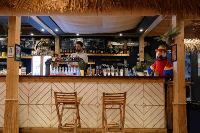 Des personnes participent à un jeu d'adresse avec des labyrinthes en bois dans un espace intérieur sur sol sablé.