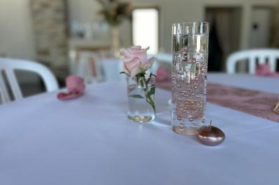 Décoration de table de mariage avec arche florale rose et blanche, bougies et arrangements floraux élégants.