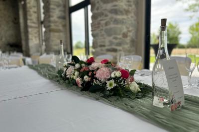 Décoration de table de mariage avec arche florale rose et blanche, bougies et arrangements floraux élégants.