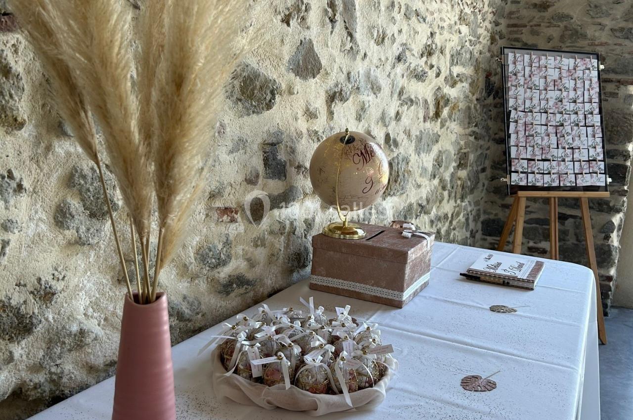 Table décorée avec un vase de pampas, un globe, des cadeaux emballés et un tableau sur chevalet en arrière-plan.