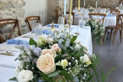 Décoration de table de mariage avec arche florale rose et blanche, bougies et arrangements floraux élégants.