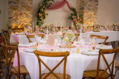 Décoration de table de mariage avec arche florale rose et blanche, bougies et arrangements floraux élégants.
