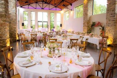 Décoration de table de mariage avec arche florale rose et blanche, bougies et arrangements floraux élégants.