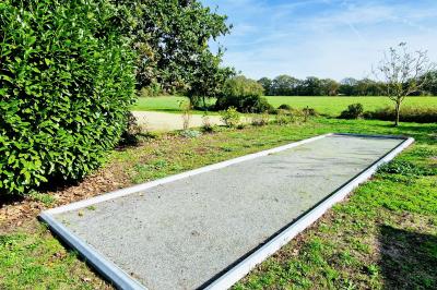 Deux lits avec couvertures bleues et marron dans une chambre lumineuse au sol en parquet et mur clair.