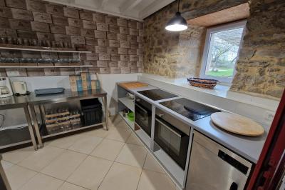 Deux lits avec couvertures bleues et marron dans une chambre lumineuse au sol en parquet et mur clair.