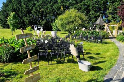 Deux lits avec couvertures bleues et marron dans une chambre lumineuse au sol en parquet et mur clair.