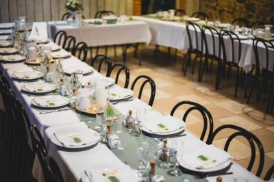 Deux lits avec couvertures bleues et marron dans une chambre lumineuse au sol en parquet et mur clair.