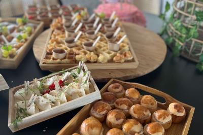 Des portions de nourriture servies dans des pots en carton avec des fleurs blanches en décoration.