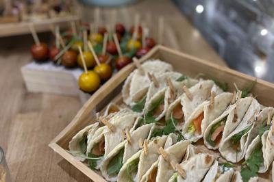 Des portions de nourriture servies dans des pots en carton avec des fleurs blanches en décoration.