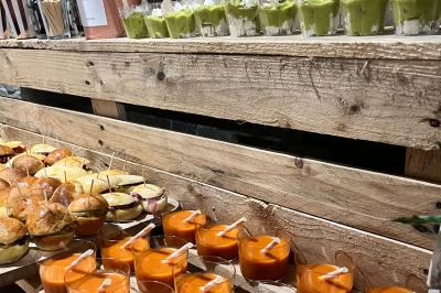 Des portions de nourriture servies dans des pots en carton avec des fleurs blanches en décoration.
