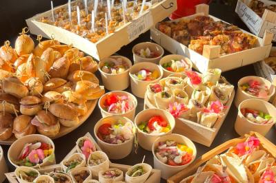 Des portions de nourriture servies dans des pots en carton avec des fleurs blanches en décoration.