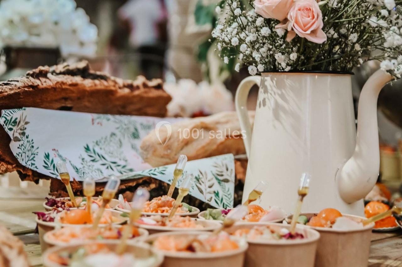 Buffet avec des plats colorés en bols individuels, décoré d'une théière blanche contenant des fleurs.