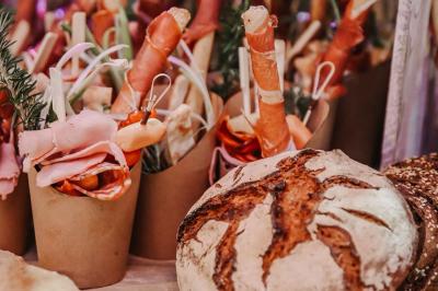 Des portions de nourriture servies dans des pots en carton avec des fleurs blanches en décoration.