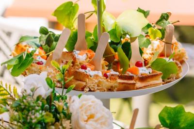 Des portions de nourriture servies dans des pots en carton avec des fleurs blanches en décoration.