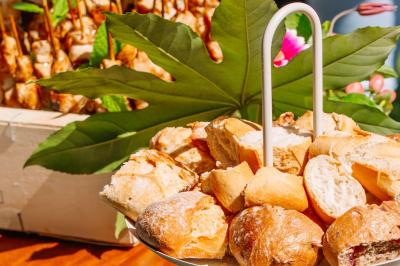 Des portions de nourriture servies dans des pots en carton avec des fleurs blanches en décoration.