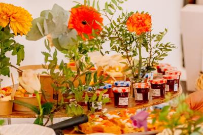 Des portions de nourriture servies dans des pots en carton avec des fleurs blanches en décoration.