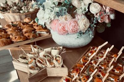 Des portions de nourriture servies dans des pots en carton avec des fleurs blanches en décoration.
