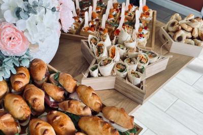 Des portions de nourriture servies dans des pots en carton avec des fleurs blanches en décoration.