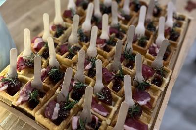 Des portions de nourriture servies dans des pots en carton avec des fleurs blanches en décoration.