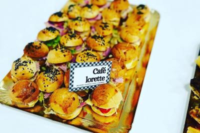 Des portions de nourriture servies dans des pots en carton avec des fleurs blanches en décoration.