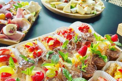 Des portions de nourriture servies dans des pots en carton avec des fleurs blanches en décoration.