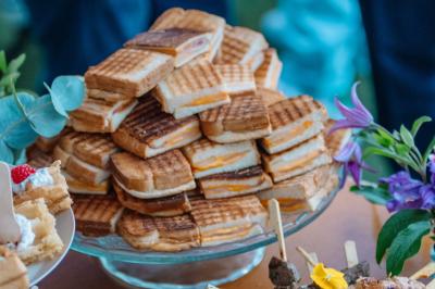 Des portions de nourriture servies dans des pots en carton avec des fleurs blanches en décoration.