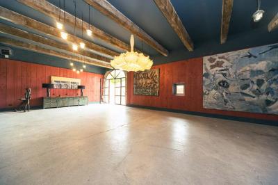 Vue aérienne d'un domaine rural avec bâtiments en pierre, cour pavée, arbres et champs environnants.