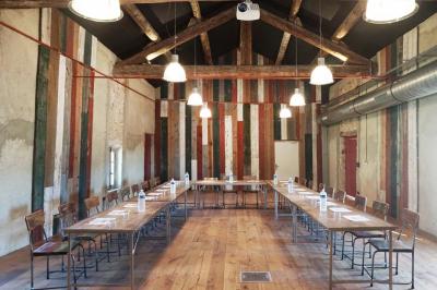 Vue aérienne d'un domaine rural avec bâtiments en pierre, cour pavée, arbres et champs environnants.