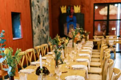 Vue aérienne d'un domaine rural avec bâtiments en pierre, cour pavée, arbres et champs environnants.