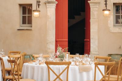 Vue aérienne d'un domaine rural avec bâtiments en pierre, cour pavée, arbres et champs environnants.