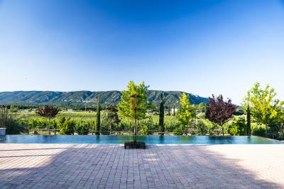Vue aérienne d'un domaine rural avec bâtiments en pierre, cour pavée, arbres et champs environnants.