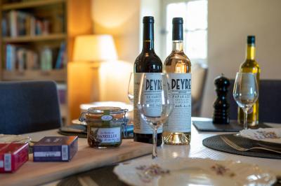 Vue aérienne d'un domaine rural avec bâtiments en pierre, cour pavée, arbres et champs environnants.