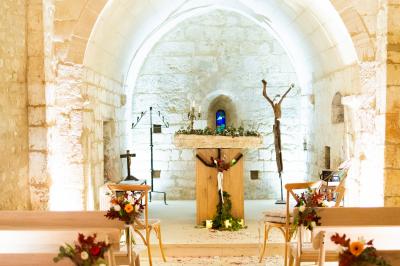 Vue aérienne d'un domaine rural avec bâtiments en pierre, cour pavée, arbres et champs environnants.