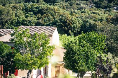 Vue aérienne d'un domaine rural avec bâtiments en pierre, cour pavée, arbres et champs environnants.