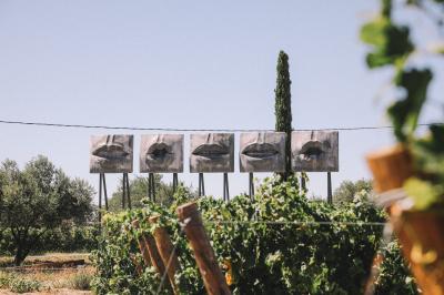 Vue aérienne d'un domaine rural avec bâtiments en pierre, cour pavée, arbres et champs environnants.