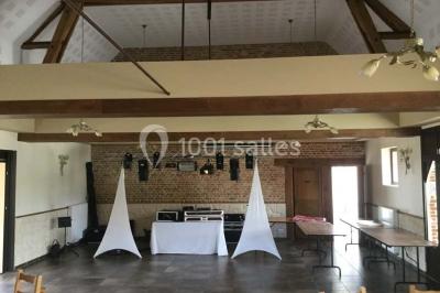 Un grand saule ombrageant un espace détente avec des palettes aménagées et des coussins sur une pelouse.